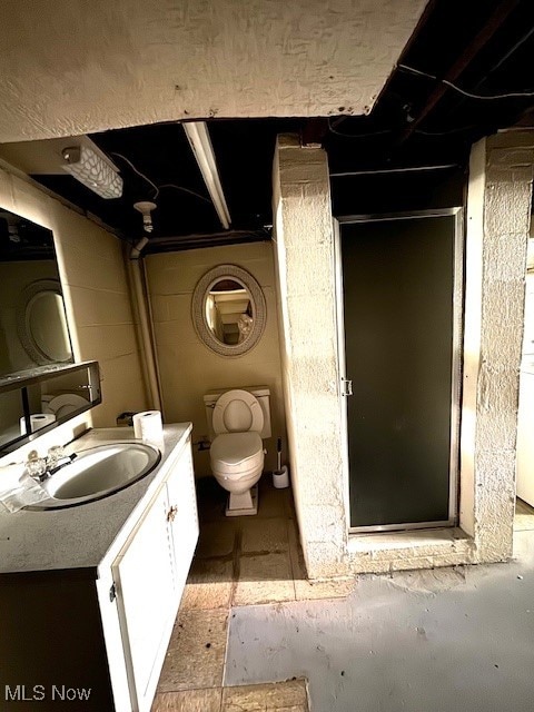 bathroom with toilet, a shower with door, and vanity