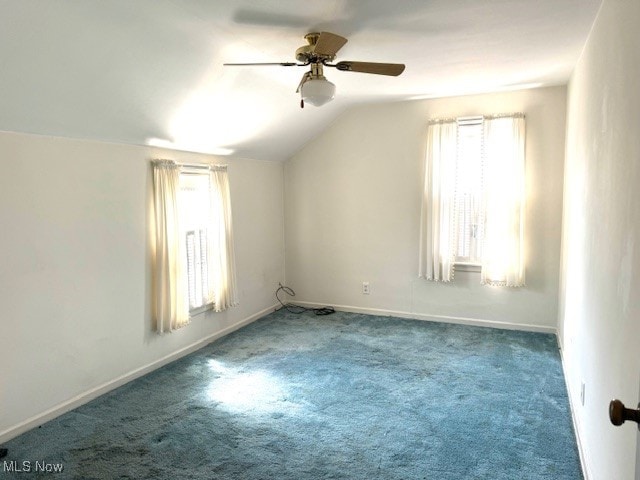 carpeted spare room featuring lofted ceiling, plenty of natural light, and ceiling fan