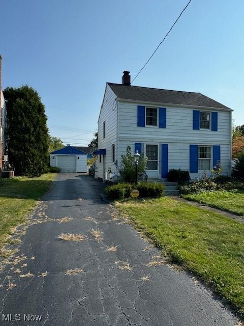 1436 Atlantic St NE, Warren, OH 44483 - view of front of home featuring an outdoor structure, a garage, and a front lawn