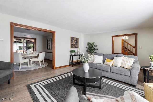 living room featuring stairs, wood finished floors, and baseboards