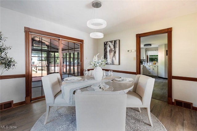 dining room featuring wood finished floors, visible vents, and baseboards