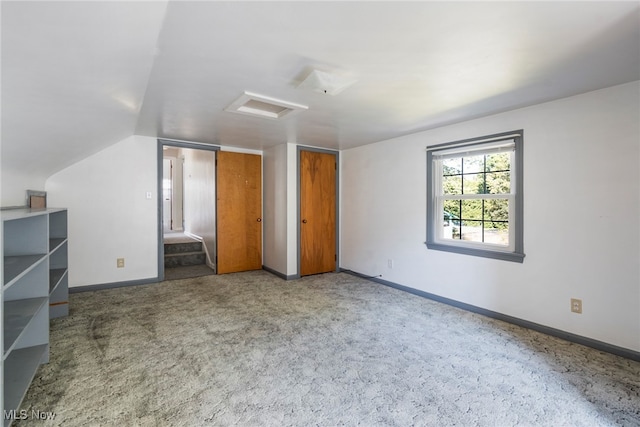 unfurnished bedroom featuring carpet flooring and vaulted ceiling