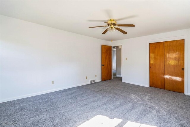 unfurnished bedroom featuring carpet floors, a closet, and ceiling fan