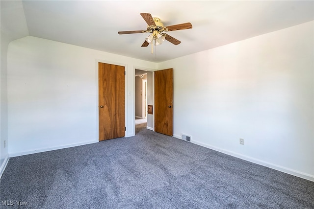 empty room with dark carpet and ceiling fan