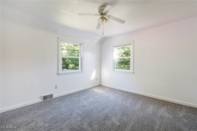 carpeted spare room with ceiling fan and plenty of natural light