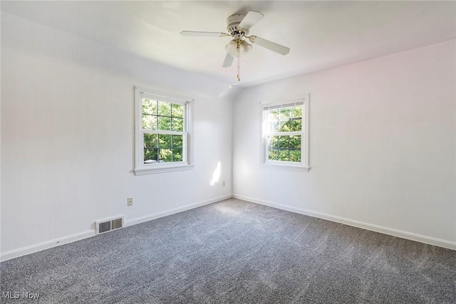 carpeted spare room with lofted ceiling, baseboards, visible vents, and a ceiling fan