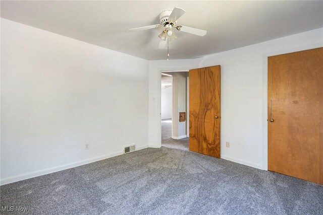 unfurnished bedroom featuring ceiling fan and dark carpet