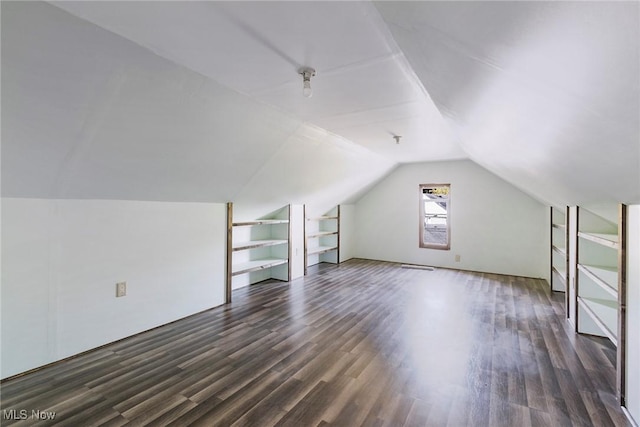 additional living space featuring lofted ceiling and dark wood-style flooring