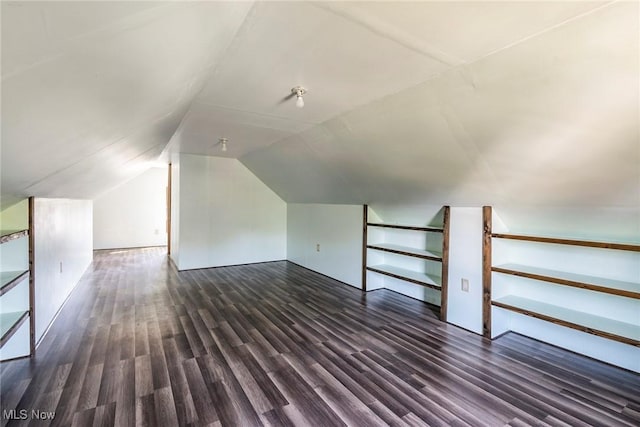 bonus room with lofted ceiling and dark wood-style flooring