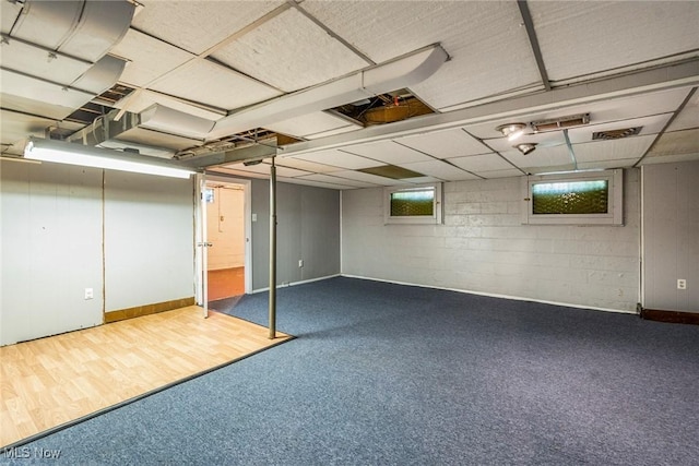 below grade area featuring wood finished floors and concrete block wall