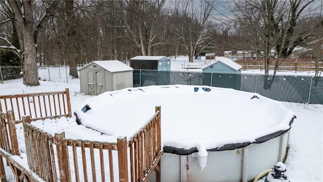 yard layered in snow featuring a storage shed