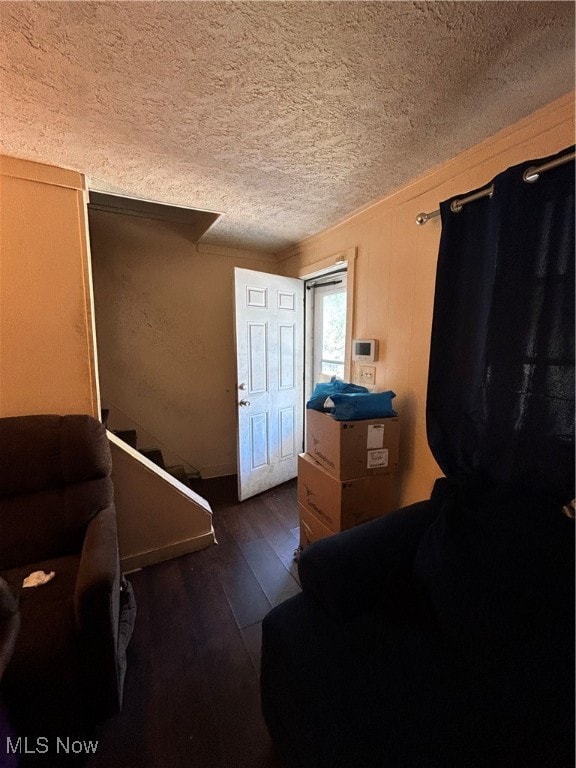 interior space featuring a textured ceiling, crown molding, and dark hardwood / wood-style flooring