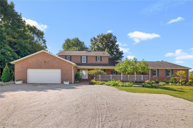 view of front of house with a garage, a porch, and a front lawn