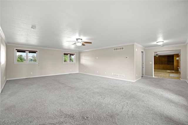 empty room with ceiling fan, ornamental molding, and carpet floors