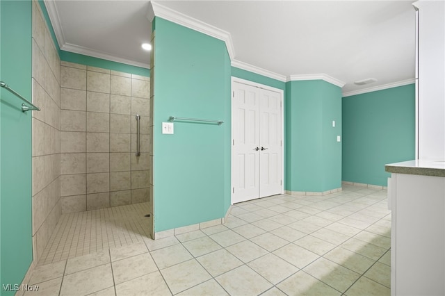 bathroom with tiled shower, ornamental molding, and tile patterned flooring