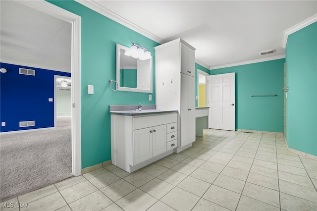 bathroom featuring tile patterned floors, crown molding, and vanity