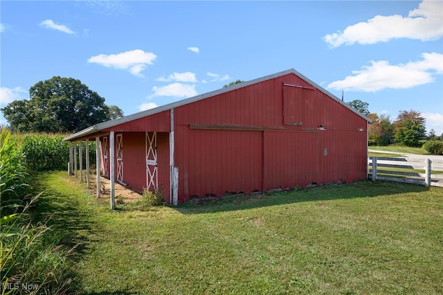 view of side of home featuring a yard and an outdoor structure