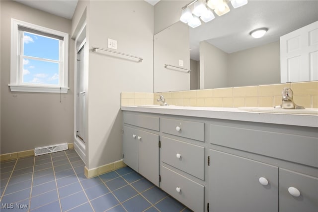 bathroom featuring a shower, tile patterned flooring, tasteful backsplash, and vanity