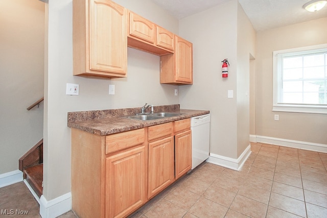 kitchen featuring dishwasher, light tile patterned floors, light brown cabinetry, and sink