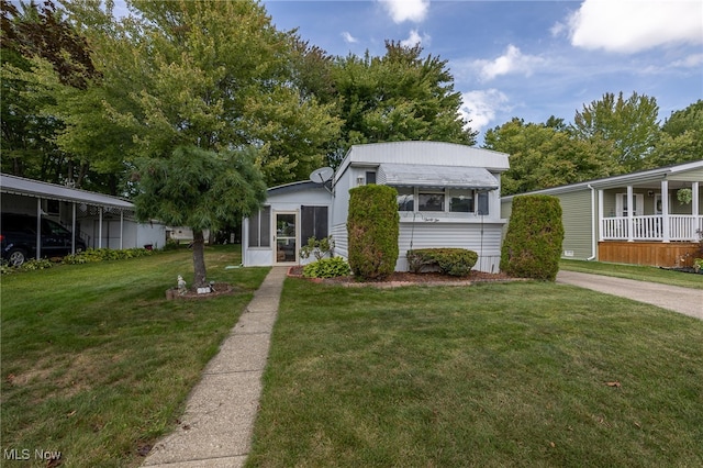 view of front facade featuring a front yard, a sunroom, and a carport