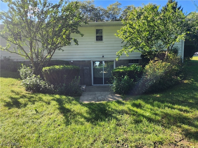 rear view of property featuring a yard