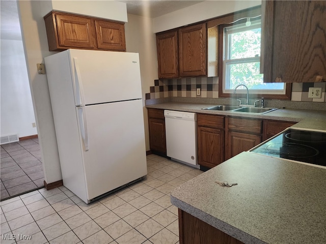 kitchen with white appliances, light tile patterned floors, and sink