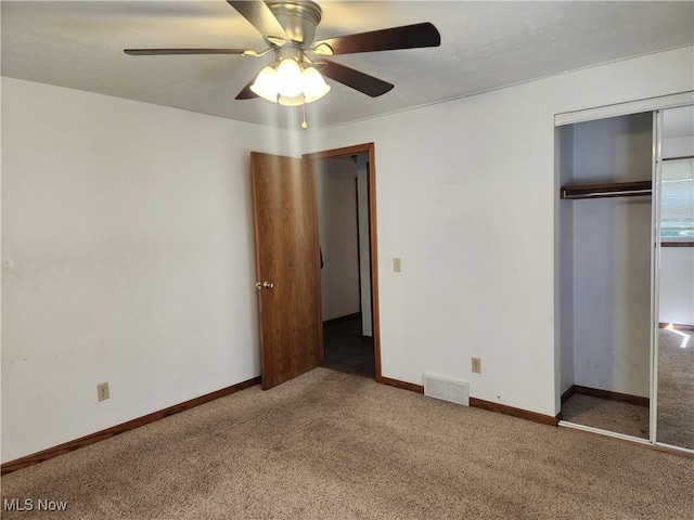 unfurnished bedroom with carpet flooring, a textured ceiling, ceiling fan, and a closet