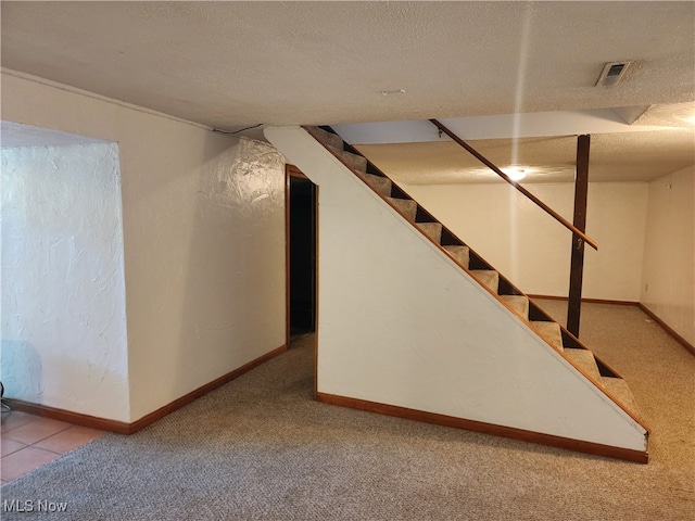 basement with a textured ceiling and light carpet