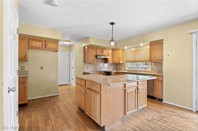 kitchen featuring hanging light fixtures, backsplash, light hardwood / wood-style floors, a kitchen island, and stainless steel dishwasher