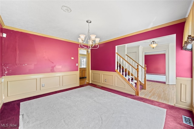 spare room featuring a notable chandelier, wood-type flooring, and crown molding