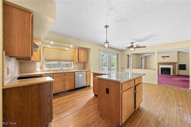 kitchen with a kitchen island, pendant lighting, light hardwood / wood-style flooring, dishwasher, and ceiling fan