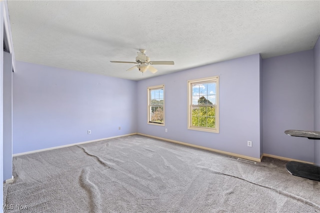 carpeted spare room with a textured ceiling and ceiling fan