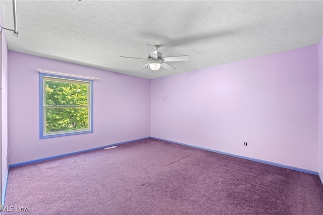 carpeted empty room featuring ceiling fan and a textured ceiling