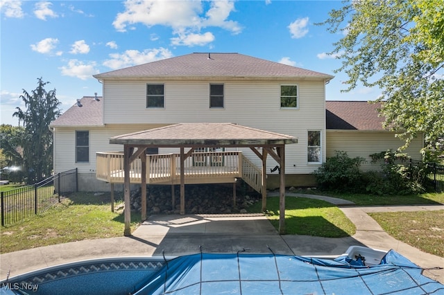 rear view of property featuring a pool side deck, a gazebo, a yard, and a patio area