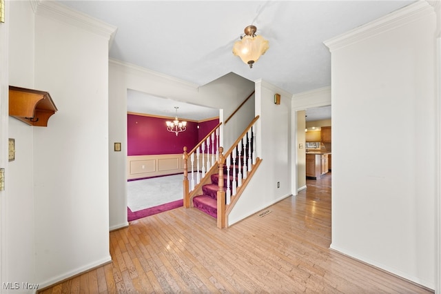 interior space with hardwood / wood-style flooring, an inviting chandelier, and ornamental molding