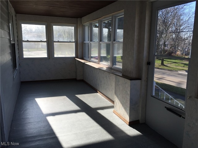 unfurnished sunroom with wood ceiling