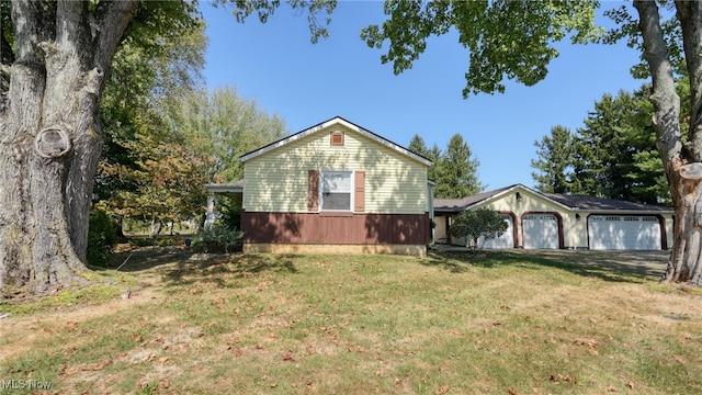 view of side of home featuring a garage and a yard