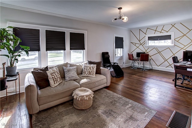 living room with crown molding, dark wood-type flooring, and an inviting chandelier