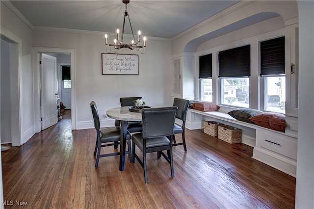 dining space featuring crown molding, an inviting chandelier, and dark hardwood / wood-style flooring