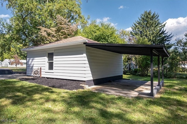 view of side of home featuring a lawn and a carport