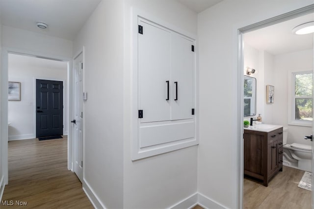 hall featuring sink and light hardwood / wood-style floors