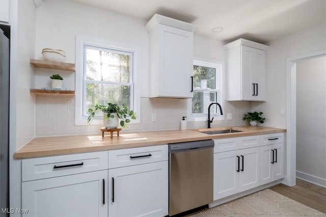 kitchen featuring dishwasher, white cabinetry, a healthy amount of sunlight, and sink