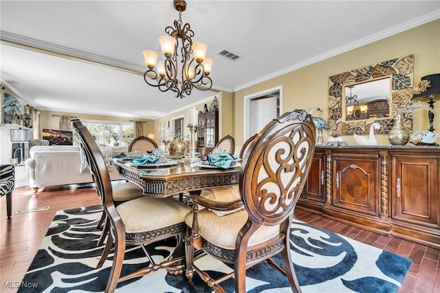 dining area featuring ornamental molding, dark hardwood / wood-style floors, and an inviting chandelier