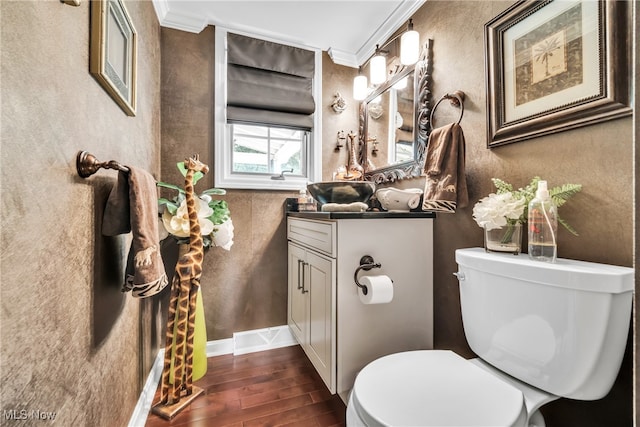 bathroom with toilet, hardwood / wood-style flooring, crown molding, and vanity