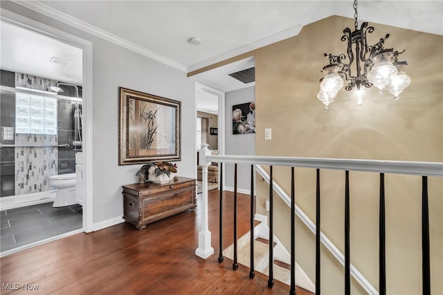 corridor with ornamental molding, dark hardwood / wood-style floors, and a chandelier