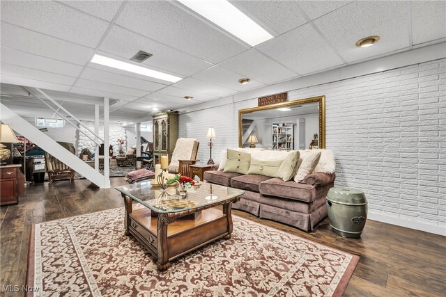 living room with a paneled ceiling and dark hardwood / wood-style flooring