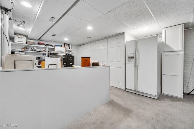 kitchen with light carpet, kitchen peninsula, white cabinets, and white refrigerator with ice dispenser