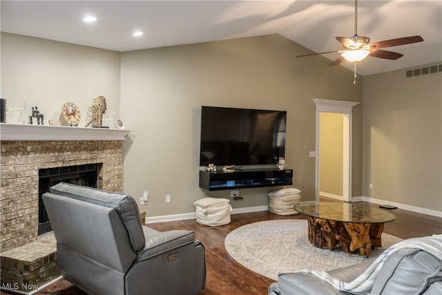 living room with lofted ceiling, ceiling fan, a brick fireplace, and hardwood / wood-style flooring