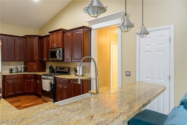 kitchen featuring pendant lighting, tasteful backsplash, dark wood-type flooring, stainless steel appliances, and lofted ceiling