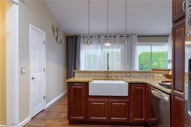 kitchen featuring dark hardwood / wood-style floors, stainless steel dishwasher, hanging light fixtures, sink, and decorative backsplash